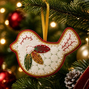 Pode incluir: Um ornamento de pássaro em feltro creme, com detalhes bordados em vermelho e dourado, aplicações em forma de folha verde e dourada com pequenas contas e uma borda vermelha. O pássaro está suspenso por uma fita dourada para pendurar.