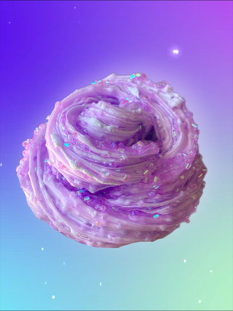May include: A swirl of lavender-colored slime with iridescent glitter accents. The slime has a textured, layered appearance, with lighter shades of purple and white interspersed throughout. The background is a gradient of purple, blue, and green.