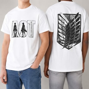 Könnte beinhalten: Ein weißes Kurzarm-T-Shirt mit einer schwarzen Grafik auf der Vorderseite, die den Text AOT und Silhouetten von zwei Figuren mit Schwertern zeigt. Die Rückseite des Shirts zeigt ein großes schwarz-weißes Flügel-Emblem in Schildform.