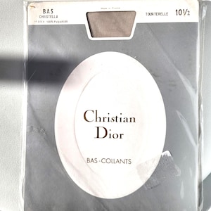 May include: A package of Christian Dior pantyhose in a gray and white design. The package includes the text "Christian Dior" and "BAS-COLLANTS". The pantyhose size is 10 1/2.