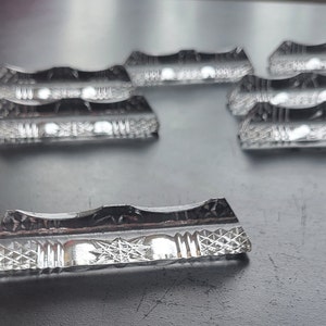 Pode incluir: Um conjunto de oito porta-cartões de lugar retangulares de vidro transparente, decorativos e gravados.