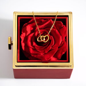 A captivating gift box containing a real preserved rose, symbolizing everlasting love. Flip the rose to reveal a personalized necklace, a timeless token of affection. Best gift for her.