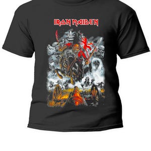 Può includere: T-shirt nera con il nome della band "Iron Maiden" in lettere rosse. La grafica raffigura una scena di battaglia con un cavaliere a cavallo, cannoni e figure fantasy in grigio, rosso e bianco. Una classica maglietta della band.
