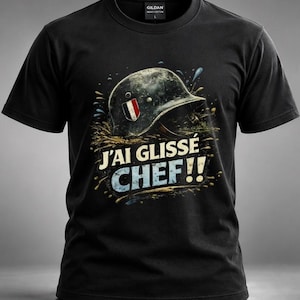 May include: A black short-sleeve t-shirt featuring a graphic of a weathered military helmet with a French flag decal, surrounded by mud splatters. Below the helmet, the text reads J'AI GLISSÉ CHEF!! in bold, distressed white and blue lettering.