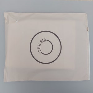 May include: A white mailing envelope with a brown circle logo that says "THE BIB" in a circular font.