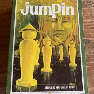 Op de afbeelding: Vintage Jumpin' bordspeldoos met een groene rand. De dooskunst toont gele spelstukken op een zwart-grijs bord, met een groot Boeddha-beeld op de achtergrond. De speltitel staat in witte blokletters.