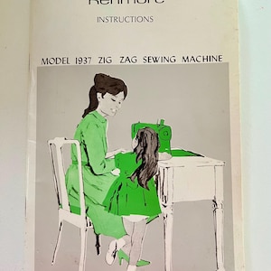 Pode incluir: Instruções da máquina de costura Kenmore vintage. A capa apresenta uma ilustração de uma mulher e uma criança usando uma máquina de costura verde. O texto diz "Model 1937 Zig Zag Sewing Machine". O fundo é cinza claro.