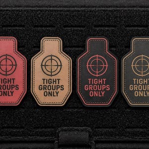 May include: Four patches in red, tan, black, and dark tan, each with a target design and the text "TIGHT GROUPS ONLY." The patches are in the shape of a target and are on a black background.