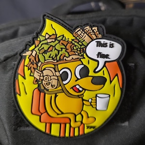 May include: A yellow patch featuring a cartoon dog sitting in a burning room, holding a mug. The dog wears a helmet and has the text "This is fine" in a speech bubble. The patch is on a black background.