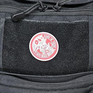 May include: A black tactical backpack with a red and white patch that says "Hang in there it gets worse".