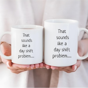 Könnte beinhalten: Zwei weiße Kaffeetassen mit schwarzem Text, der "That sounds like a day shift problem....." lautet.