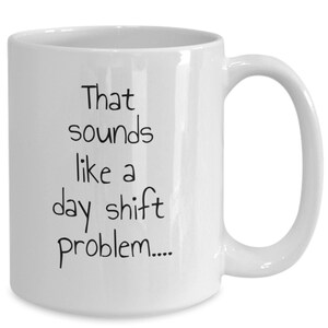 Könnte beinhalten: Weiße Keramik-Kaffeetasse mit schwarzem Text, der "That sounds like a day shift problem..." lautet.