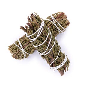 May include: Two bundles of dried green and brown herbs, tightly wrapped with white string. The bundles are arranged on a white background, showcasing the natural textures and colors of the herbs.