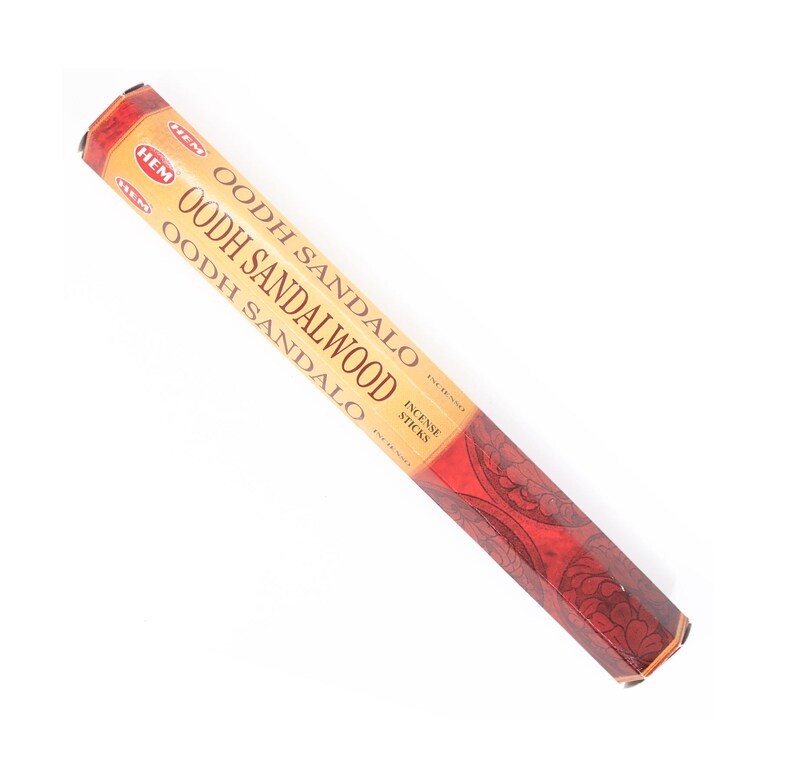 May include: A package of HEM Oodh Sandalwood incense sticks. The packaging is primarily tan with red accents and features the product name in large, bold letters. The bottom of the package has a red floral design.