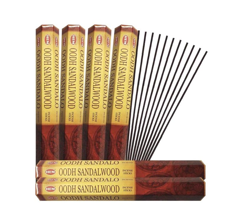 May include: An assortment of HEM Oodh Sandalwood incense sticks. The image shows several boxes of incense sticks, with the brand name and product name printed on the packaging. A bundle of black incense sticks is also visible.