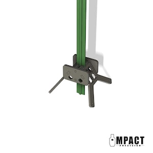 May include: A gray metal stand with a green support structure. The stand has a rectangular base with angled legs and a logo that says "IMPACT PRECISION". The stand is designed to hold a vertical object.