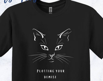 May include: Black t-shirt with a white cat face graphic and the text "Plotting Your Demise." The image includes blue jeans, white sneakers, and sunglasses. The brand name "Five Sprouts Tees" is at the top.