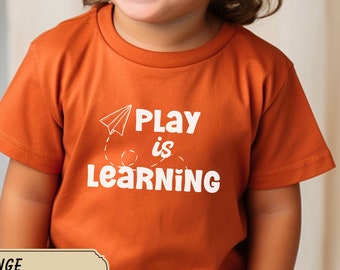 T-Shirt „Spielen ist Lernen“ für Kleinkinder. T-Shirt für Kleinkinder aus Freilandhaltung