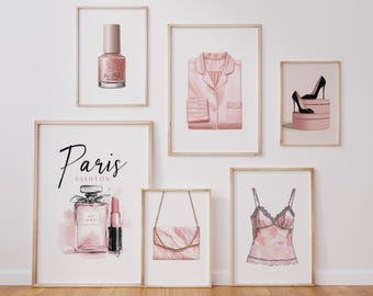 May include: A collection of framed art prints featuring fashion-themed illustrations. Prints include a nail polish bottle, a pink pajama top, high heels, a perfume bottle, a lipstick, a handbag, and a camisole. The color palette is primarily pink and black.