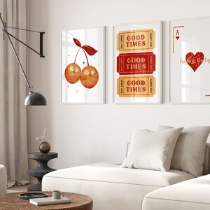 Peut inclure: Trois impressions encadr&eacute;es sur un mur blanc. L'impression de gauche repr&eacute;sente une cerise rouge avec un motif de paillettes dor&eacute;es. L'impression du milieu repr&eacute;sente trois billets rouges avec le texte "Good Times" sur chacun. L'impression de droite repr&eacute;sente un as de pique rouge avec le texte "feeling lucky" dessus.