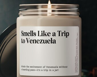 May include: A lit candle in a glass jar with a silver lid. The label reads "Smells Like a Trip to Venezuela." The text below says "Inhale the excitement of Venezuela without a boarding pass--it's a trip in a jar!"