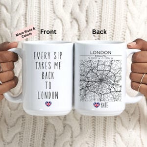 May include: A white ceramic mug featuring the text 'EVERY SIP TAKES ME BACK TO LONDON' with a small Union Jack heart icon on the front, and a black and white map of London with coordinates and the name 'KATE' on the back.
