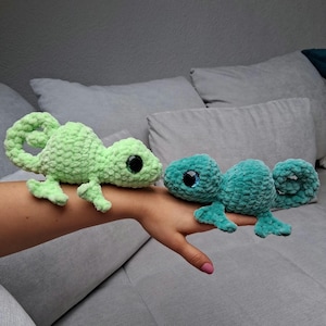 Könnte beinhalten: Zwei gehäkelte grüne Eidechsenspielzeuge mit großen Glitz Augen. Die Eidechse links ist hellgrün und die Eidechse rechts ist dunkelgrün.