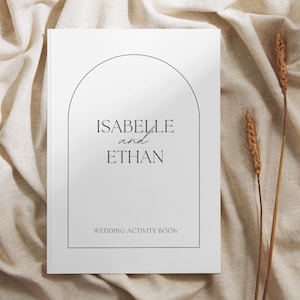 May include: A white wedding activity book with a black arch design and the text "Isabelle and Ethan" and "Wedding Activity Book".