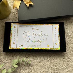 May include: A gold and white gift card with a holographic finish. The card says "Just for you! Mum City break in Edinburgh! Happy Birthday! From Brody & Amy x".