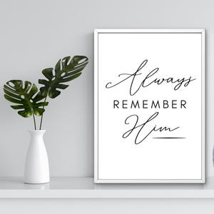 May include: A framed print with the words "Always Remember Him" in elegant black script. A digital download label is on the right. A white vase with green leaves is on the left.