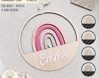 Könnte beinhalten: Wanddekoration aus Holz mit Regenbogenmotiv, rosa und beige Bögen, einem weißen Herz und dem Namen "Emma". Das Design ist in einem kreisförmigen Rahmen angeordnet. Der Text oben lautet "RAINBOW LOOP - 3 SIZES".