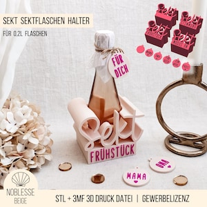 Könnte beinhalten: Ein rosa 3D-gedruckter Flaschenhalter mit den Worten "Sekt" und "Frühstück" in Magenta. Eine kleine Flasche wird gehalten, mit einem Anhänger mit der Aufschrift "Für Dich". Zusätzliche Dekorationselemente sind enthalten.