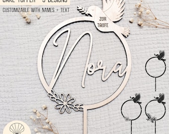 May include: A wooden cake topper with three designs. The first design features a dove with an olive branch in its beak and the text "Zur Taufe". The second design features a circle with the name "Nora" written inside. The third design features a circle with a floral design.