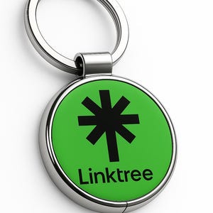 May include: A round, silver keychain with a green center. The center features a black asterisk symbol and the word "Linktree" in white. The keychain has a silver ring for attaching keys.