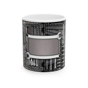 Puede incluir: Taza de cerámica blanca con un diseño envolvente con el tema de la caja de herramientas. El diseño incluye varias herramientas como llaves y enchufes en tonos grises y negros, con un rectángulo gris en blanco en el centro.