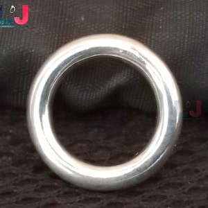 Peut inclure: Une bague en argent avec une finition lisse et polie. La bague est ronde et a un grand centre ouvert.