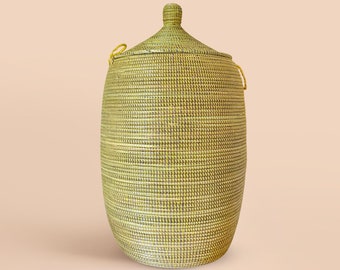 May include: A large, woven storage basket with a lid and handles. The basket is made of natural materials and has a light green color.
