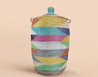 May include: A large, colorful woven basket with a lid. The basket is made of natural materials and has a geometric pattern in shades of blue, green, yellow, pink, and red.