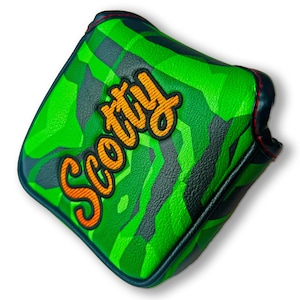 May include: Green and black camouflage golf club head cover with a bright orange "Scotty" logo.