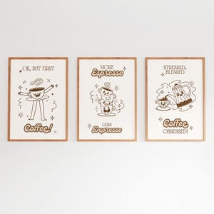 Puede incluir: Tres impresiones artísticas enmarcadas con ilustraciones y texto sobre el tema del café. Las impresiones tienen un fondo claro con marcos marrones. El texto incluye "OK, BUT FIRST Coffee!", "MORE Espresso LESS Depresso" y "STRESSED, BLESSED Coffee OBSESSED!"