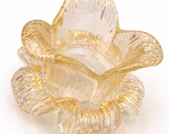 May include: A clear glass flower-shaped decorative bowl with gold accents. The bowl has a layered petal design and a textured surface. The gold detailing adds a touch of elegance to the piece. Ideal for home decor.