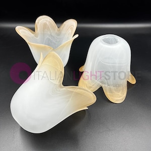 Könnte beinhalten: Drei weiße Glaslampenschirme mit einem braunen Wirbelmuster. Die Lampenschirme haben die Form einer Blume mit fünf Blütenblättern.