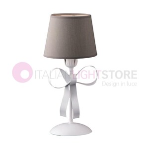 Op de afbeelding: Witte tafellamp met een grijze lampenkap van stof en een witte strik op de voet. De lamp staat op een witte achtergrond.