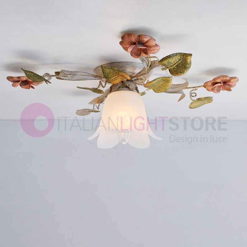 K&ouml;nnte beinhalten: Eine wei&szlig;e Deckenleuchte mit floralem Design. Die Leuchte hat f&uuml;nf Arme, jeder mit einem Blatt und einer Blume. Die Blumen sind rosa und gelb. Die Leuchte hat einen wei&szlig;en Glasschirm in Form einer Blume.