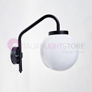 Può includere: Applique da parete nera con un paralume bianco a forma di globo. L'applique ha un braccio curvo e una base rotonda.