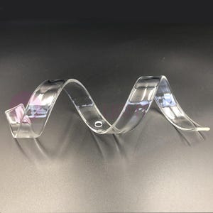 Può includere: Tubo per tende in plastica trasparente con un design a spirale. Il tubo ha un foro al centro.