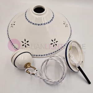 Op de afbeelding: Witte keramische hanglamp met blauwe bloemenrand en uitgesneden bloemmotieven. Inclusief bijpassende keramische bal en gevlochten wit snoer. Ontworpen voor plafondverlichting.