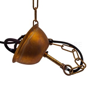 May include: A vintage-style pendant light fixture with a brass-colored, bell-shaped shade. The fixture includes a chain, a black electrical cord, and a brass-colored rod. The light is suspended from a chain and is designed for overhead lighting.