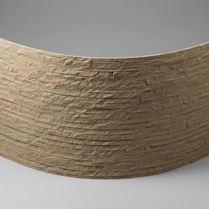 May include: A curved wall panel featuring a stacked stone design with a textured, light brown finish. The panel consists of multiple horizontal, narrow stone strips layered to create a rugged, dimensional surface with natural variations in colour.