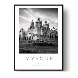 May include: A black and white framed wall art print featuring the Mysore Palace in India. The text below the image reads MYSORE, INDIA, and the coordinates 12.2958° N, 76.6394° E. The print is enclosed in a thin black frame with a white border.